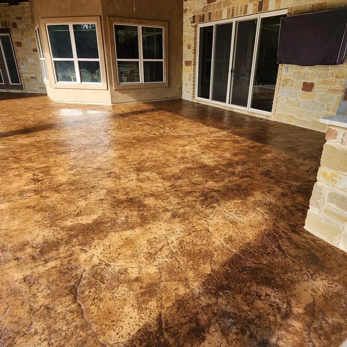beautiful concrete patio with textured overlay and rustic brown stain